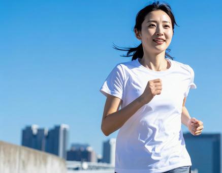 都会を走る女性ランナー 都会を走る女性ランナーの写真