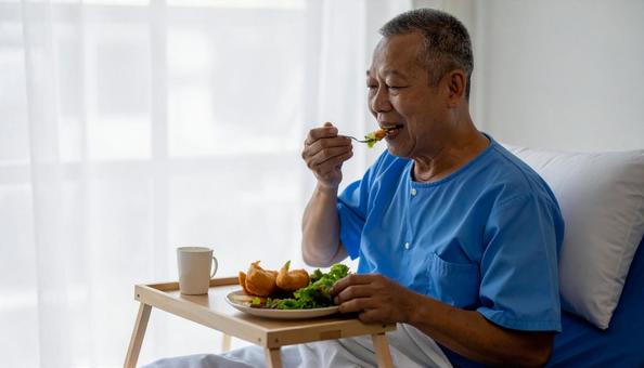端座位で食事をするシニア男性の患者 端座位で食事をするシニア男性の患者の写真