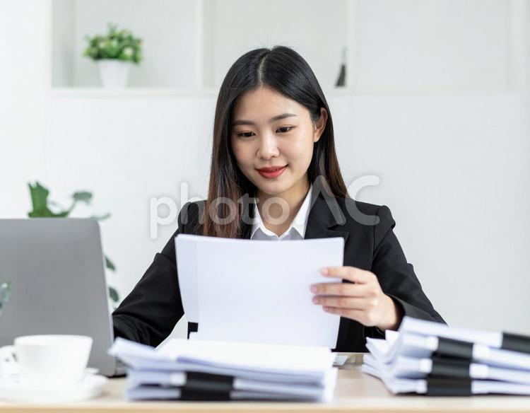 たくさんの書類を処理する女性社員 書類,オフィス,女性の写真素材