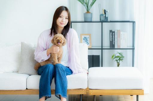 部屋でペットとくつろぐ若い女性 部屋でペットとくつろぐ若い女性 ペット,女性,犬の写真素材