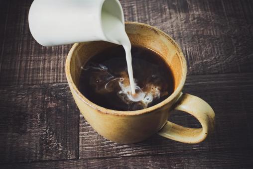 コーヒーにミルクを注ぐ コーヒーにミルクを注ぐの写真