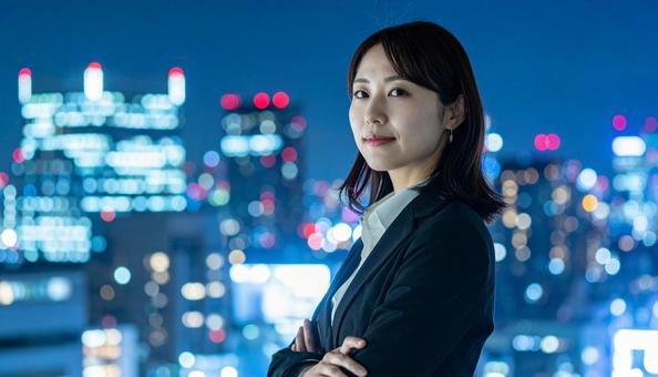 都市の夜景を背景に佇むビジネスマン 都市の夜景を背景に佇むビジネスマンの写真