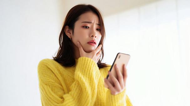 不安げなスマホ確認 不安げなスマホ確認の写真