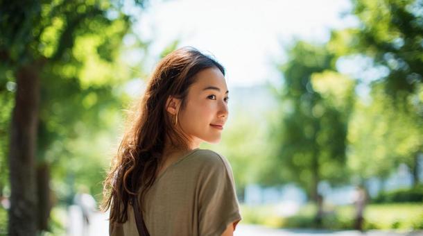 公園を一人で歩く女性 公園を一人で歩く女性の写真