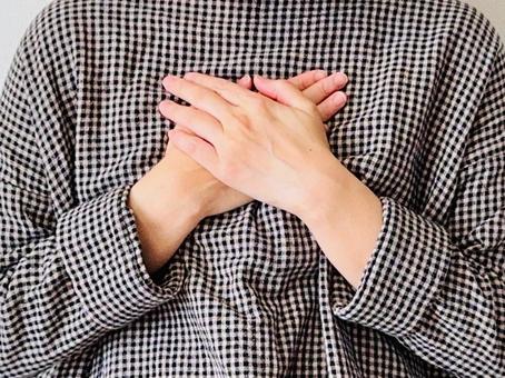 胸に両手をあてるチェック柄の服の女性 ホッとする,女性,主婦の写真素材