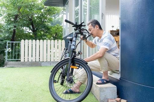 電動自転車をメンテナンスをするミドル男性 電動自転車,男性,ミドルの写真素材