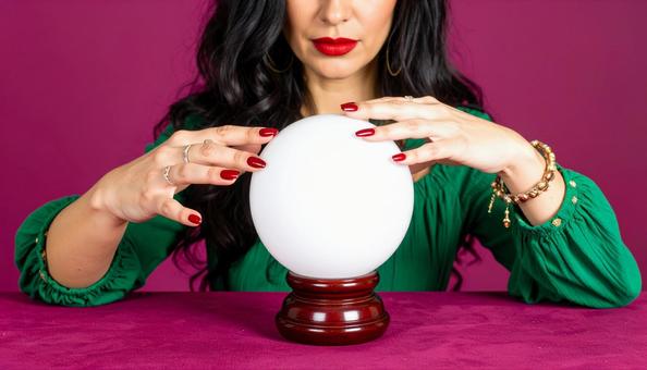 水晶占いで水晶玉をのぞき込む女性の占い師 水晶占いで水晶玉をのぞき込む女性の占い師の写真