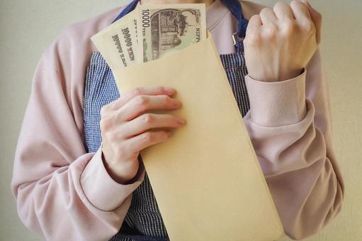 封筒のお金を持ち喜ぶ主婦1 封筒,お金,金の写真素材
