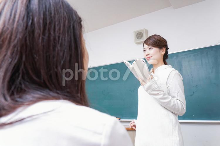 本を持って授業をする女性教師 教育無償化,テスト,卒業の写真素材