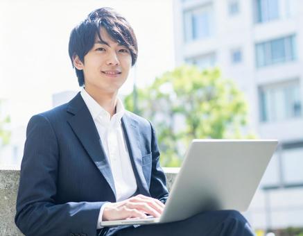 ノートパソコンを操作する若い男性 ノートパソコンを操作する若い男性の写真