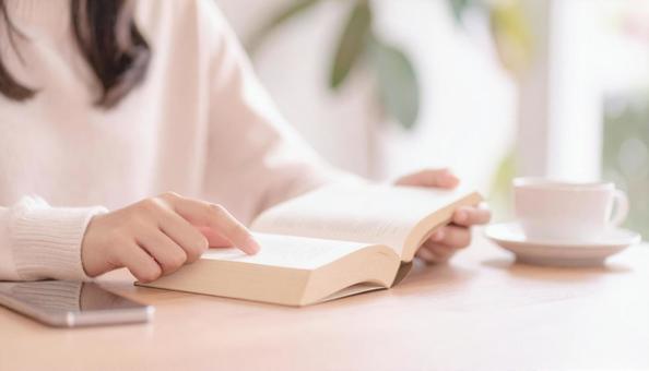 読書する女性の手元アップの写真