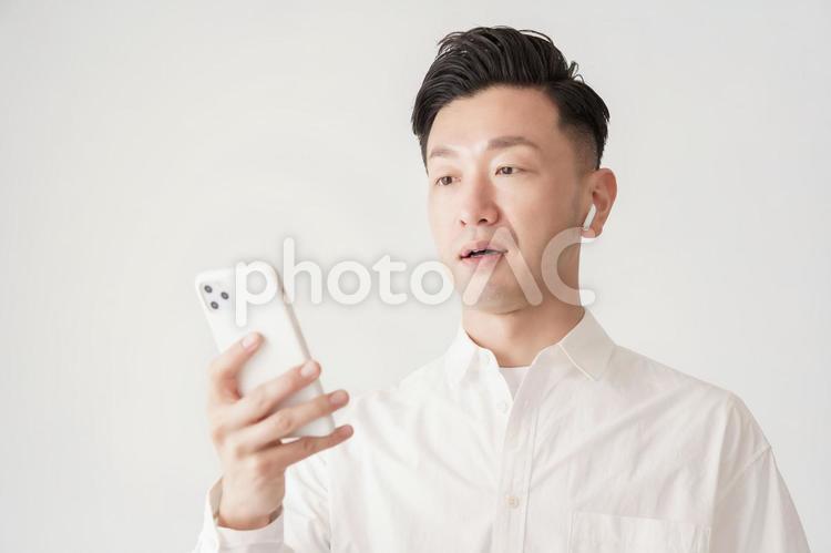 スマートフォンの画面を見る男性  男性,スマホ,日本人の写真素材