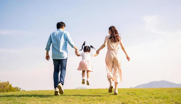 春の公園を歩く家族の後ろ姿 春の公園を歩く家族の後ろ姿の写真