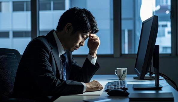 疲労で限界で頭を抱える男性会社員 疲労で限界で頭を抱える男性会社員の写真