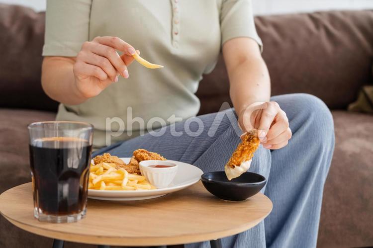 座ってフライドチキンとポテトを持つ人の手元 手元,女性,人物の写真素材