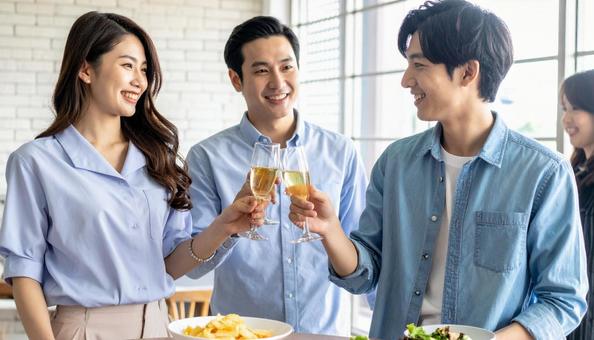 パーティーで乾杯をする若い男女 パーティーで乾杯をする若い男女の写真