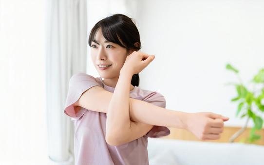 自宅のリビングでストレッチをする女性 自宅のリビングでストレッチをする女性 女性,ストレッチ,柔軟の写真素材