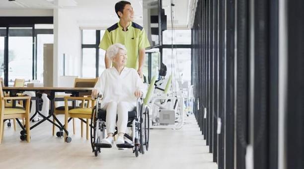 車椅子で散歩をする高齢者と介護士 車椅子で散歩をする高齢者と介護士 高齢者,車椅子,介護士の写真素材