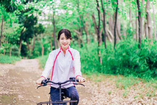 自然の中でサイクリングを楽しむ若い女性 自然の中でサイクリングを楽しむ若い女性 レンタルサイクル,散策,山の写真素材