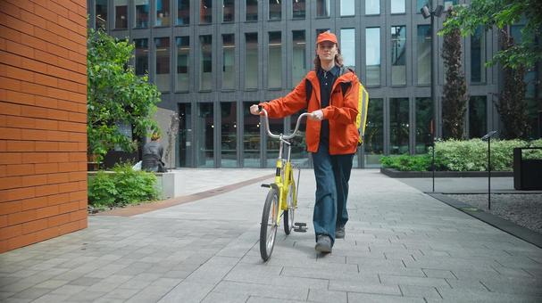自転車を押して歩いているフードデリバリーの男性 配達,フードデリバリー,デリバリーの写真素材