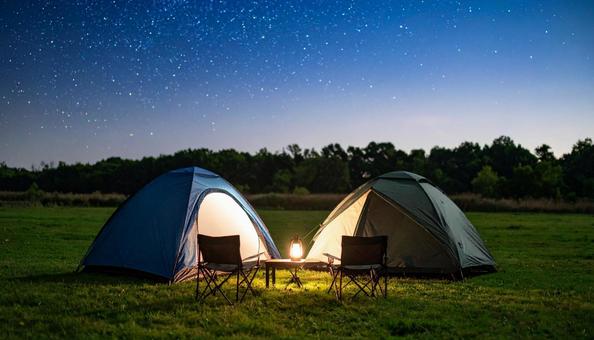 夜の星空の下の焚き火とテントキャンプ 夜の星空の下の焚き火とテントキャンプの写真