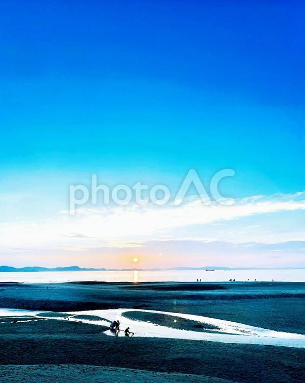 夕陽と青い空の下で遊ぶ親子 エメラルドグリーン,スカイブルー,バカンスの写真素材