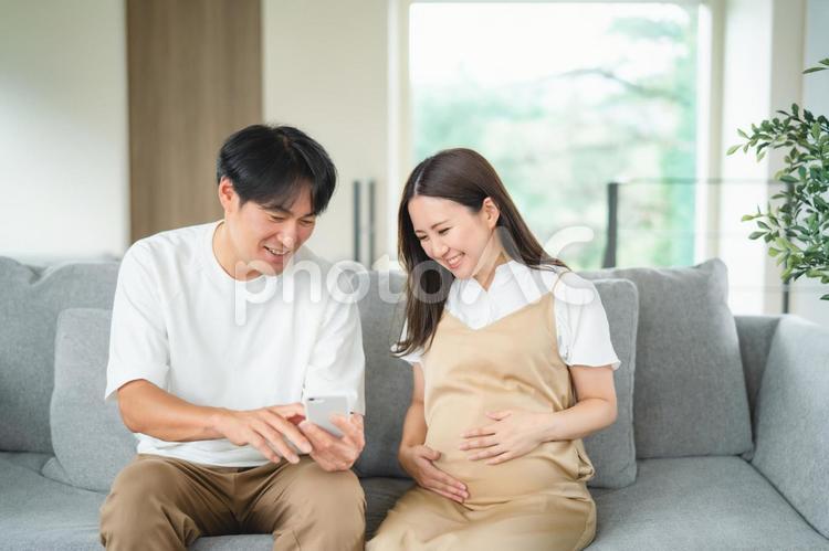 スマホを見る妊婦と男性 妊婦,妊娠,夫婦の写真素材
