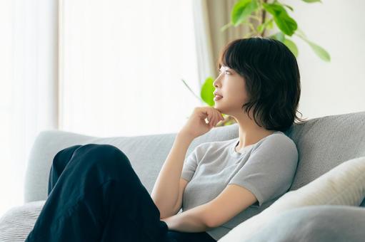 リビングのソファに座る女性 リビングのソファに座る女性の写真