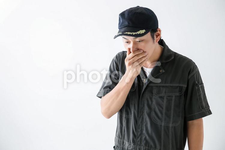 口に手をあてる整備士 1人,30代,40代の写真素材