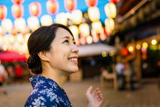 浴衣を着て夏祭りを楽しむ日本人女性 浴衣を着て夏祭りを楽しむ日本人女性の写真