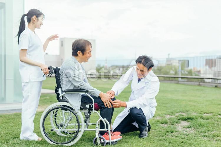 リハビリをする患者と医療スタッフ（足を見る） リハビリ,車椅子,入院の写真素材