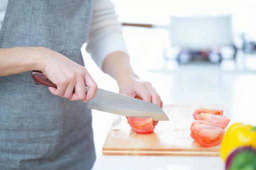 トマトを包丁で切る人の手 トマトを包丁で切る人の手の写真