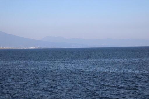 青い海面の海と霞む街と山と青空の風景 青い,海面,海の写真素材
