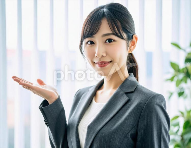 案内ポーズをするスーツ姿の女性 女性,ビジネス,スーツの写真素材