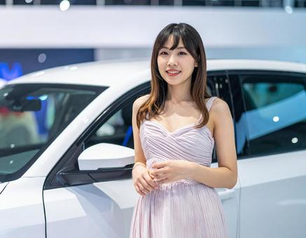 車の横に立つキャンペーンガール 車の横に立つキャンペーンガールの写真