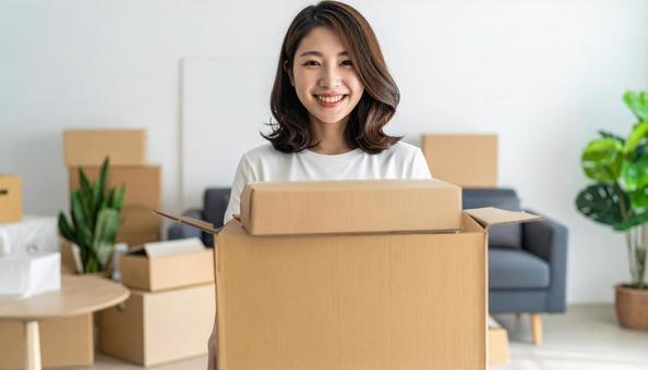 微笑みながら引越し作業をする女性 微笑みながら引越し作業をする女性の写真