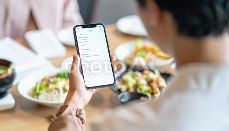 携帯からメニューを注文する手元 注文,携帯電話,メニューの写真素材