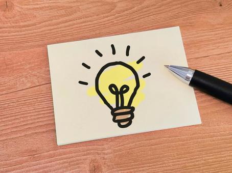 木目調の机の上に置かれた豆電球の絵 木目調の机の上に置かれた豆電球の絵 アイデア,豆電球,ポイントの写真素材