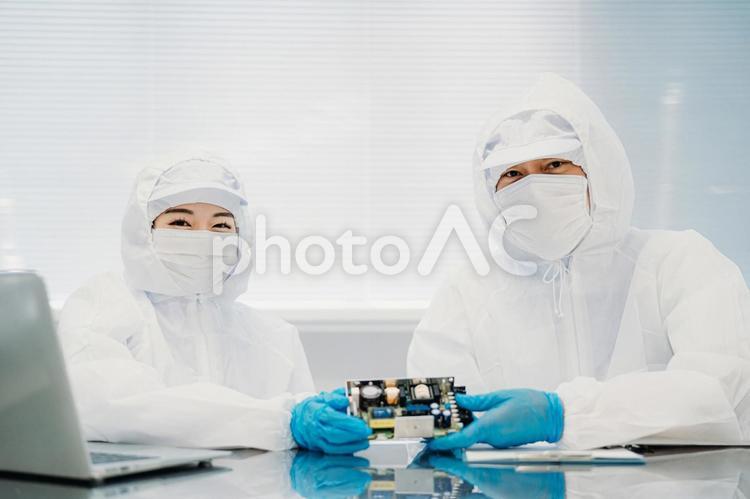 クリーンルームで精密機器を扱う男女 工場,クリーンルーム,製造業の写真素材