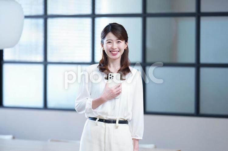 スマホを持ち笑顔のカメラ目線女性 女性,スマートフォン,持つの写真素材