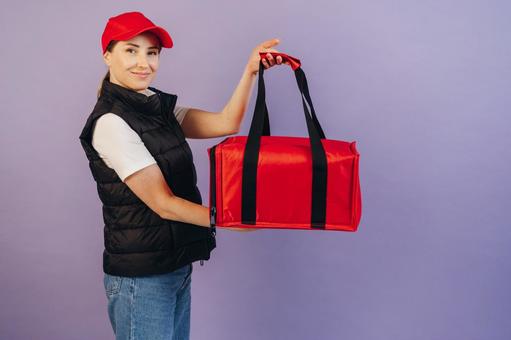 保温ピザバッグを見せる女性配達員 配達,フードデリバリー,デリバリーの写真素材