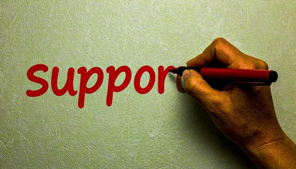 文字「Support」と赤ペンで書く手元 文字「Support」と赤ペンで書く手元の写真