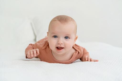 笑顔の腹ばいの赤ちゃん 笑顔の腹ばいの赤ちゃん 赤ちゃん,かわいい,うつ伏せの写真素材