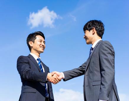 握手するビジネスマン男性二人 握手するビジネスマン男性二人の写真