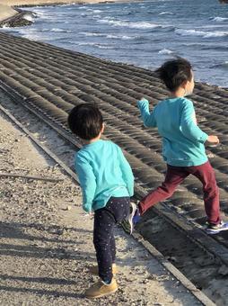 海辺でかけ回る子どもたち 海辺でかけ回る子どもたちの写真