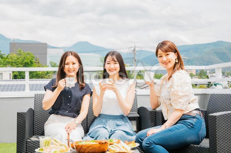 屋上でお茶会をする女性たち 女子会,カフェ,ランチの写真素材
