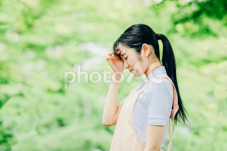 エプロンをつけた女性（頭） 介護士,看護師,疲労の写真素材