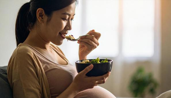 食事を美味しそうに食べる妊婦 食事を美味しそうに食べる妊婦の写真