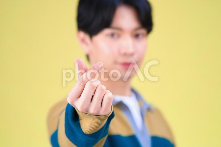 指ハートをする男性の手のアップ 指ハート,手元,アップの写真素材