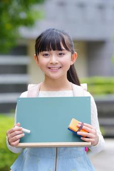 屋外で黒板を持っている女の子 子ども,女の子,小学生の写真素材